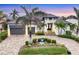 Luxury home with a modern design, palm trees, and a paved driveway at 1371 Grebe Dr, Punta Gorda, FL 33950