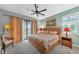 Bright bedroom with king-size bed, sliding doors to patio, and ceiling fan at 13836 Alafaya St, Venice, FL 34293