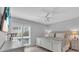 Bedroom with whitewashed furniture, ceiling fan, shuttered windows, and a wall mounted television at 1555 Tarpon Center Dr # 238, Venice, FL 34285