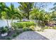 Property entrance with manicured landscaping, palm trees, and white privacy wall at 1555 Tarpon Center Dr # 238, Venice, FL 34285