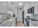 Bright kitchen features white cabinetry, stainless steel appliances and marble countertops at 1555 Tarpon Center Dr # 238, Venice, FL 34285