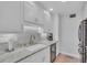 Bright kitchen features white cabinets, marble countertops, and stainless steel appliances at 1555 Tarpon Center Dr # 238, Venice, FL 34285