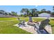 Stone firepit surrounded by comfortable gray chairs on a brick patio at 1661 Columbia Dr, Englewood, FL 34223