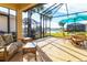 Relaxing screened patio overlooking a lake with seating area and umbrella at 173 Padova Way # 17, Nokomis, FL 34275