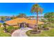 Tan house with tile roof, palm trees, and landscaped yard at 1815 Killdeer Ct, Venice, FL 34293