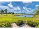 Landscaped backyard featuring a pond and golf course views at 1891 San Silvestro Dr, Venice, FL 34285