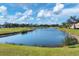 Beautiful backyard with lush landscaping, a pond, and golf course views at 1891 San Silvestro Dr, Venice, FL 34285
