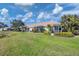 Spacious backyard with screened patio, lush landscaping, and pond view at 1891 San Silvestro Dr, Venice, FL 34285