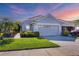 Attractive tan house with two-car garage at sunset at 1891 San Silvestro Dr, Venice, FL 34285