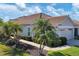 Tan house with two-car garage and tropical landscaping at 1891 San Silvestro Dr, Venice, FL 34285