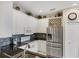 Modern kitchen features white cabinets, granite counters, and stainless steel appliances at 1891 San Silvestro Dr, Venice, FL 34285