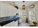 Bright kitchen nook boasts granite counters, white cabinets, and a built-in desk at 1891 San Silvestro Dr, Venice, FL 34285