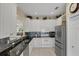 Modern kitchen features white cabinets, granite counters, and stainless steel appliances at 1891 San Silvestro Dr, Venice, FL 34285