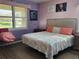 Main bedroom with coral bedding and large window at 19010 Mangieri St, Venice, FL 34293