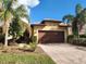 Exterior of a single-Gathering home with a brown garage door and landscaped yard at 19010 Mangieri St, Venice, FL 34293