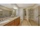 Elegant bathroom with dual sinks, granite countertops, and a walk-in shower at 19500 Petrino St, Venice, FL 34293