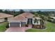 Single-story home with tile roof, gray garage doors, and landscaped yard at 19500 Petrino St, Venice, FL 34293