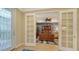 Home office with built-in cabinetry, wood desk, and French doors at 19500 Petrino St, Venice, FL 34293