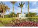 Community entrance sign with palm trees and flowers at 19807 Bridgetown Loop, Venice, FL 34293