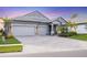 Two-story house with gray siding, three-car garage, and landscaped yard at 19807 Bridgetown Loop, Venice, FL 34293