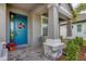 Inviting front porch with blue door and wicker chairs at 19807 Bridgetown Loop, Venice, FL 34293
