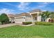 One-story home with light-colored exterior, two-car garage, and nicely landscaped yard at 2136 Mesic Hammock Way, Venice, FL 34292