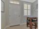 Small foyer with round table and chairs, white door, and window with shutters at 2136 Mesic Hammock Way, Venice, FL 34292