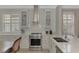 Modern kitchen with white cabinets, stainless steel appliances, and quartz countertops at 2136 Mesic Hammock Way, Venice, FL 34292