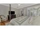 Main bedroom with a post bed, TV, comfortable seating area, and backyard access at 2136 Mesic Hammock Way, Venice, FL 34292