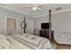 Main bedroom features a post bed, TV, ceiling fan, and an ensuite bathroom at 2136 Mesic Hammock Way, Venice, FL 34292
