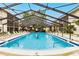 Community pool with screened enclosure and loungers at 2280 Stickney Point Rd # 437, Sarasota, FL 34231