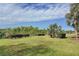 Landscaped backyard with green grass and mature trees at 23619 Awabuki Dr, Venice, FL 34293