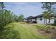 Home with a large backyard, screened patio, and mature trees at 2751 Lavandula Ct, North Port, FL 34289