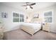 Spacious bedroom with a king-size bed, ceiling fan, and large windows at 2751 Lavandula Ct, North Port, FL 34289