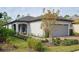 One-story house with gray garage door, landscaping, and walkway at 2751 Lavandula Ct, North Port, FL 34289