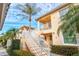 Exterior view of two-story condo building with stairs and tropical landscaping at 4206 Vicenza Dr # C24, Venice, FL 34293