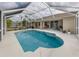 Inviting pool area with screened enclosure, patio furniture, and lush landscaping at 4743 Butterfly Ln, North Port, FL 34288