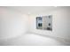 Empty bedroom with large window and simple white walls at 5055 N Beach Rd # 201, Englewood, FL 34223