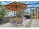 Covered patio with table, chairs, and umbrella, adjacent to the pool at 518 Boxwood Ln, Englewood, FL 34223