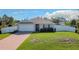 Newly constructed home with a white vinyl fence and a brick paver driveway at 5552 Guest Ter, Port Charlotte, FL 33981