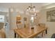 Light-filled dining room with a large wooden table and six chairs at 560 Fallbrook Dr, Venice, FL 34292