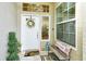 Front entry with white door, welcome mat, and decorative bench at 560 Fallbrook Dr, Venice, FL 34292