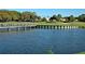 Picturesque lake with wooden bridge and golf course in background at 560 Fallbrook Dr, Venice, FL 34292
