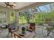 Relaxing screened lanai with patio furniture, ceiling fans, and lush landscaping views at 560 Fallbrook Dr, Venice, FL 34292
