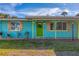 Inviting teal home with green door, wood accents, and landscaped yard at 609 W Perry St, Englewood, FL 34223