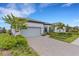 Single-story home with gray garage door, landscaping, and paver driveway at 6260 Talon Preserve Dr, Nokomis, FL 34275