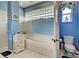 Bathroom with a toilet and a bathtub with glass block window at 660 Silk Oak Dr, Venice, FL 34293