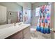 Bathroom with white vanity, tub, and colorful shower curtain at 660 Silk Oak Dr, Venice, FL 34293