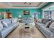 Bright living room featuring comfy sofas and a large glass coffee table at 660 Silk Oak Dr, Venice, FL 34293