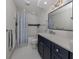 Stylish bathroom with a navy vanity, bathtub, and shower at 703 Ironwood Dr # 114, Venice, FL 34292
